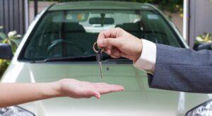 Une femme qui achète une voiture reçoit les clés du vendeur
