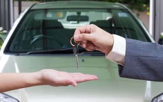 Une femme qui achète une voiture reçoit les clés du vendeur